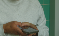 Ung dreng i går sweatshirt bruger sin mobiltelefon